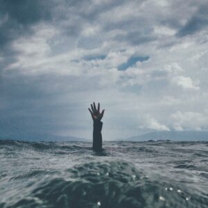 This is a picture of someone sinking and raising a hand in the air for help. It is to symbolise burning out at work and needing help which is what this blog post is for. To stop burnout and to help your business grow and achieve its goals.