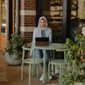 The picture is of a person looking happy on their laptop to show how knowing about your finances as a business owner makes you happier, more relaxed and in control of your business