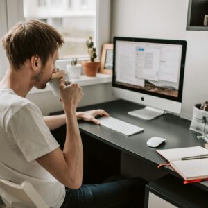 This is a picture of a business owner relaxed and working at his desk for following the tips in this blog